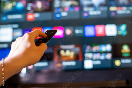 Close-Up of Hand Aiming Remote at Smart TV with Streaming Apps