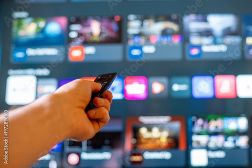 Hand Holding Remote Control Toward Smart TV Streaming Menu