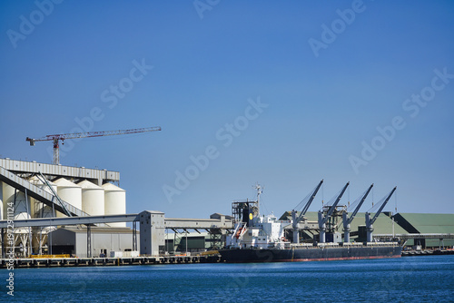 Cargo ship docked at Geralton Port Western Australia view of loading cranes on a clear day