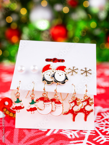 Close-up of a set of Christmas earrings featuring reindeer, penguins, Christmas trees, and other festive designs