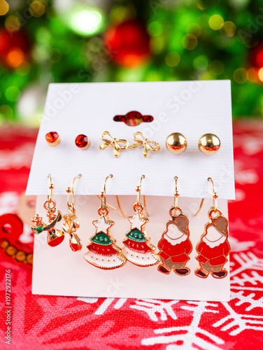 Close-up of a set of Christmas earrings featuring a gnome, Christmas tree, reindeer, and other holiday-themed designs