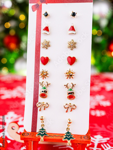 Close-up of a set of Christmas earrings featuring reindeer, Christmas trees, snowflakes, and other festive designs