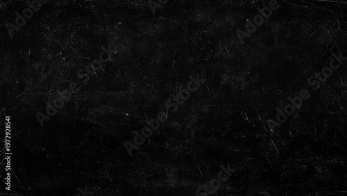 Black scratched surface with scratches and marks on a dark textured background, grunge effect