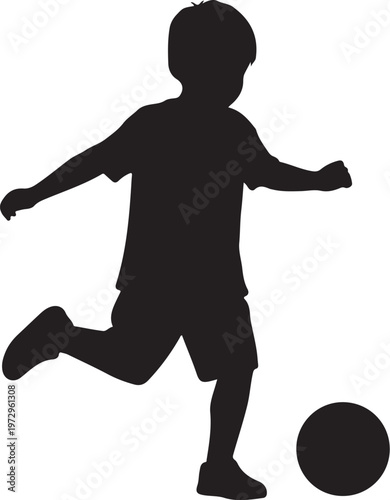 Black silhouette of a boy kicking a ball