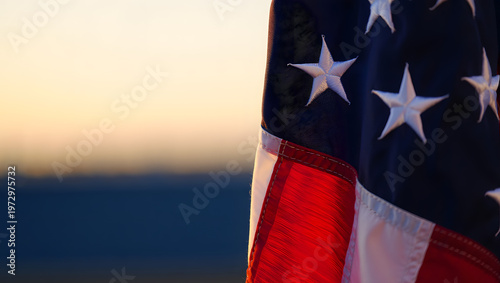 Star-Spangled Banner: A close-up view of the American flag, its stars and stripes waving gently in the breeze against a backdrop of a gradient sky, symbolizing patriotism and freedom.