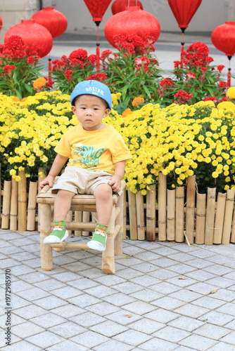 A dog in a tshirt models for the camera in a traditional Vietnamese holiday display. 