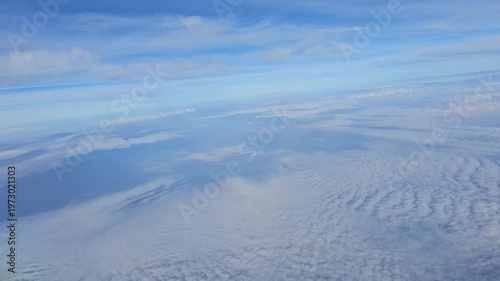 Spectacular high-altitude video from an airplane window showing a vast expanse of white clouds beneath a deep blue sky over the Andaman region.