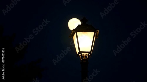 Full Moon Illuminates a Vintage Street Lamp at Night.