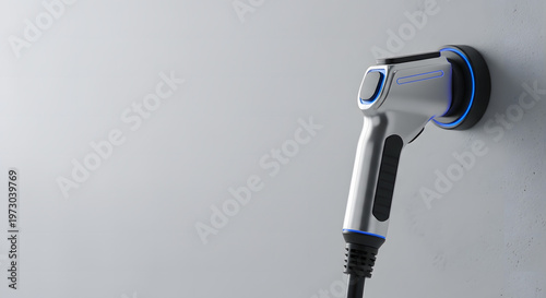 Modern electric vehicle charging connector plugged into a wall-mounted port with blue light accents.