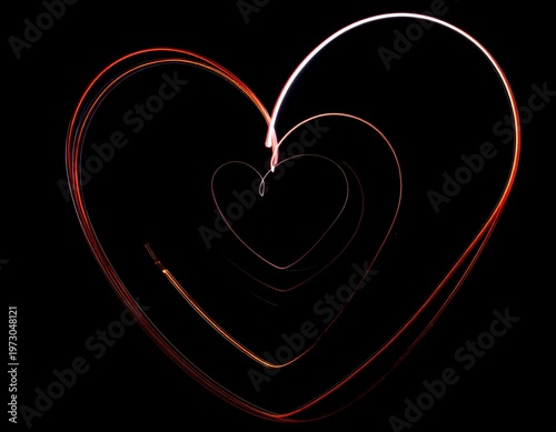 Glowing light trails trace a heart shape on black, creating an abstract and romantic design