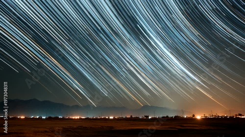 Star Trails Over Mountains with City Lights at Night