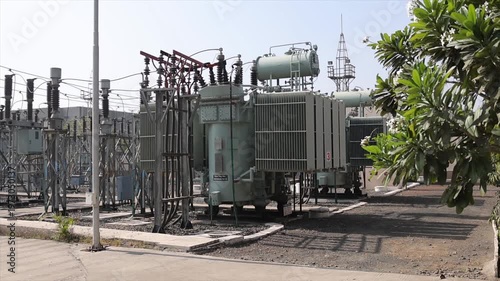 Electrical Power Substation with High Voltage Transformers and Insulators in Outdoor Industrial Yard
