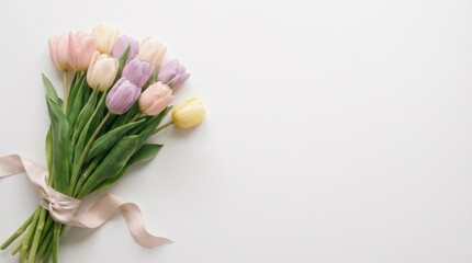 Bouquet of pastel tulips with ribbon on white background. Spring flower arrangement for greeting card. Floral concept for Easter, Mother day and wedding celebration with copy space.