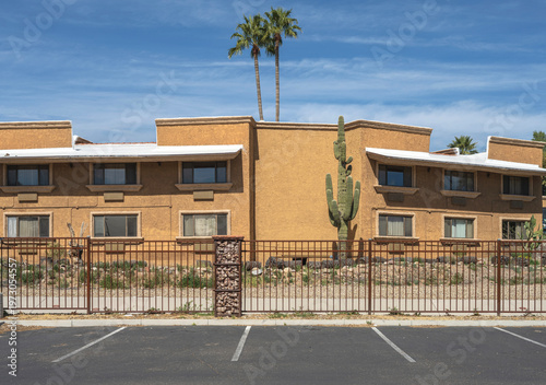 Wikenburg Arizona two palms and a cactus with a building.