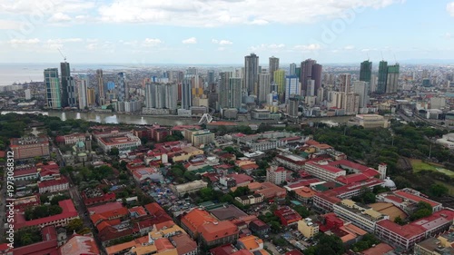 Aerial drone view of Manila skyline with Intramuros historic district in the foreground. Contrast between old colonial architecture and modern cityscape in Philippines capital.