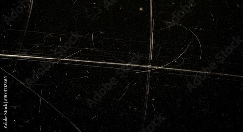 Close-up view of a heavily scratched and dusty dark surface, resembling old film or a distressed texture overlay.
