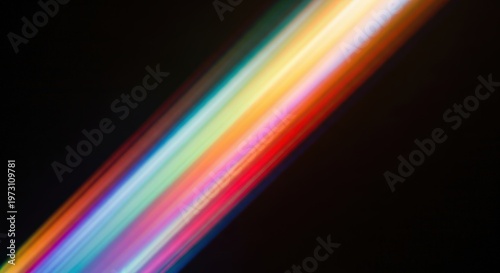 A vibrant, colorful diagonal light streak against a dark black background, showcasing a spectrum of blended hues.