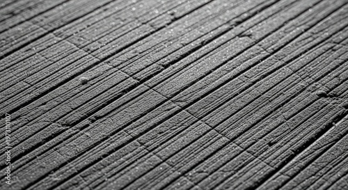 Close-up view of a textured concrete surface with numerous parallel diagonal grooves and lines, creating a strong pattern of light and shadow.