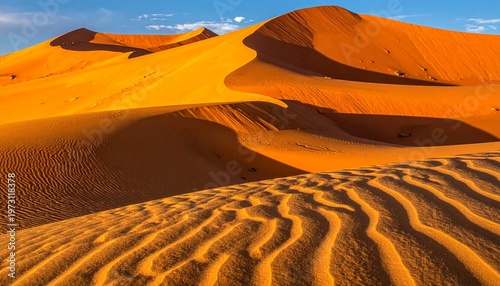 Golden sand dunes with wave-like patterns under warm sunset lighting