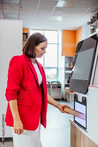 Photography woman returning book at self service library machine looking at camera with conf