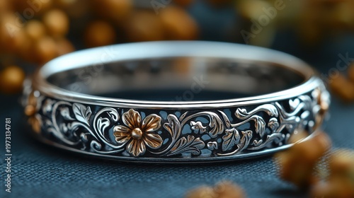 Elegant floral silver bracelet with intricate gold accents.