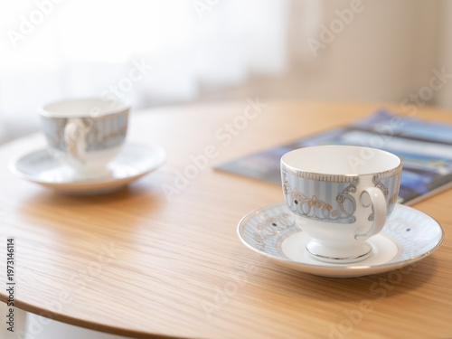 Two teacups on round wooden table in bright interior