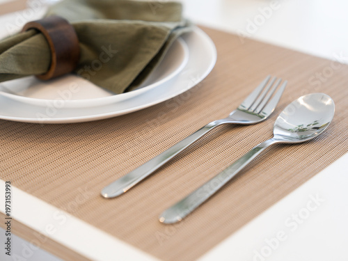 Close-up of table setting with fork and spoon in bright modern interior
