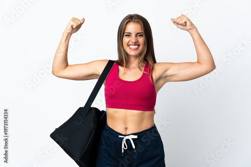 Young sport Uruguayan woman with sport bag isolated on white background doing strong gesture