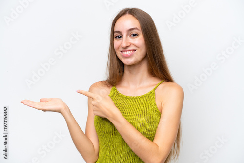 Young caucasian woman isolated on white background holding copyspace imaginary on the palm to insert an ad