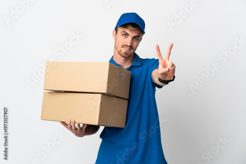 Quadro su tela Young delivery blonde man isolated on white background smiling and showing victo
