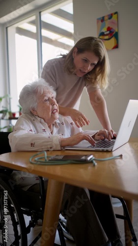 Daughter helping elderly mother use laptop and online banking.