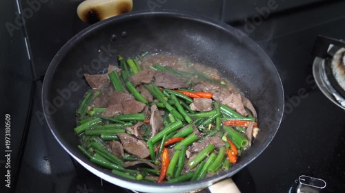 Close-up of stir-fried pork liver with fresh green onions and chili for healthy Thai home cooking and iron-rich meal concept
