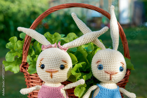 Toy bunnies in a basket with salad on a Sunny summer day