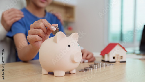 Foto Child saving money in a piggy bank with parental guidance