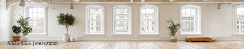 Minimalist loft studio with large arched windows and natural light, ideal for wellness and creative spaces