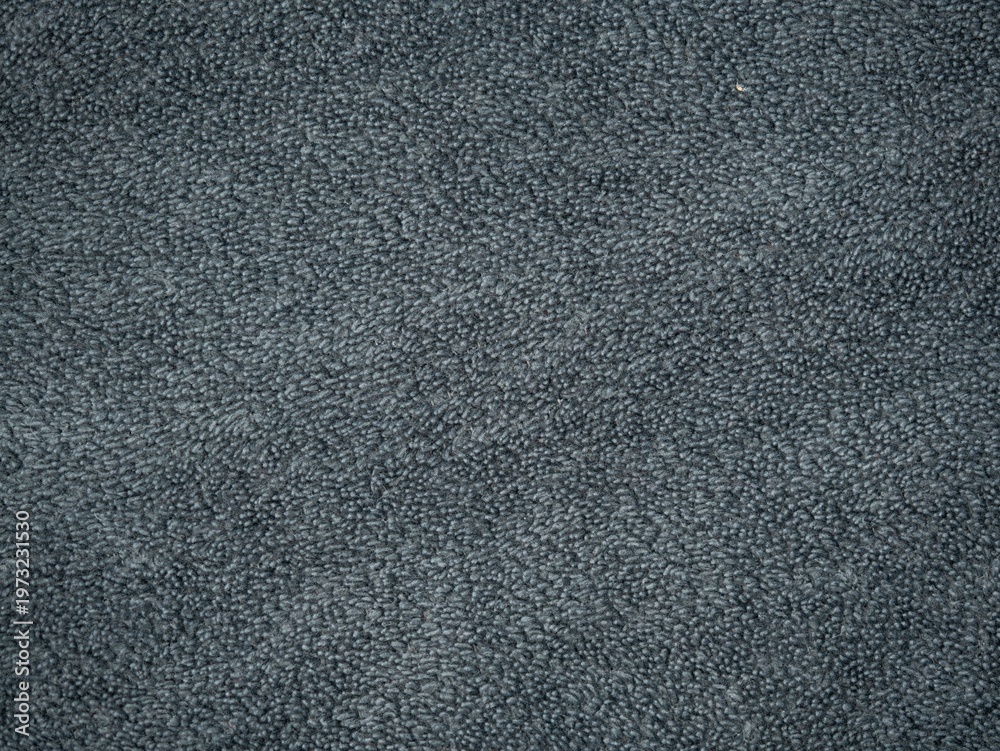 Fototapeta premium Close-up texture of dark gray terry cloth towel or carpet fabric, soft looped fibers forming an even background surface.