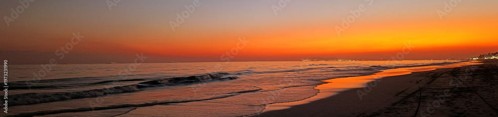 Obraz premium Orange sunset on Al Haffa beach in Salalah, Oman. Web banner with copy space