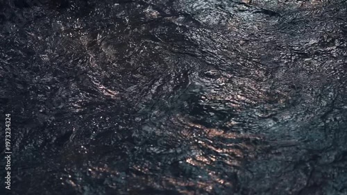 Flowing water surface texture with ripples and reflections in slow motion, Abstract liquid pattern with dynamic movement and shimmering light on water 4k