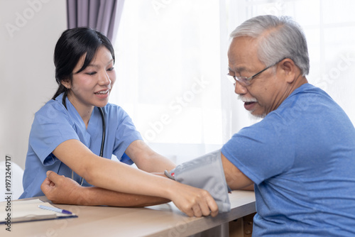 Tableau sur toile Nurse measuring blood pressure of senior man during home healthcare visit