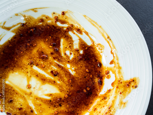 Dirty plate top view background, finished eat dinner in restautant, abstract textuer stain smearing drip sauce bbq jam chilli jelly on ceramic breakfast, concept for clean hyginene product