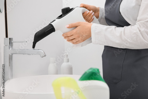 Female janitor steam cleani...