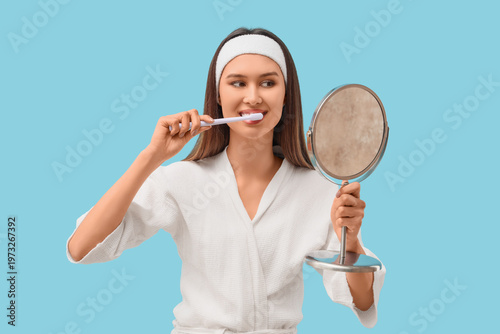 Young woman in bathrobe bru...