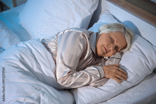 Senior woman sleeping in be...