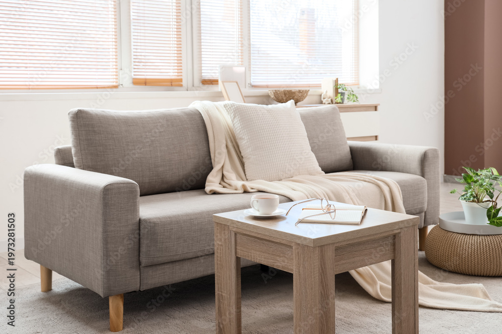 Fototapeta premium Interior of stylish living room with grey sofa, coffee table and window
