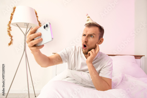 Shocked young man with mobi...