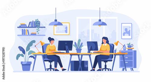 Two women working together at computers in an office setting.