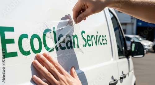 Applying EcoClean Services Decal to a White Van.
