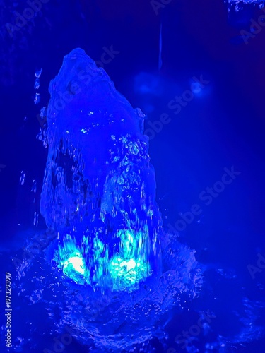 Abstract fountain water illuminated in blue color at night