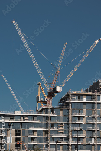 Construction site of modern residential buildings cranes and industrial machines at day, Abu Dhabi