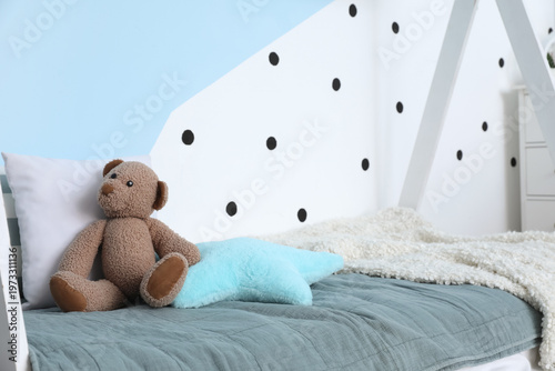 Toy bear with pillows on be...